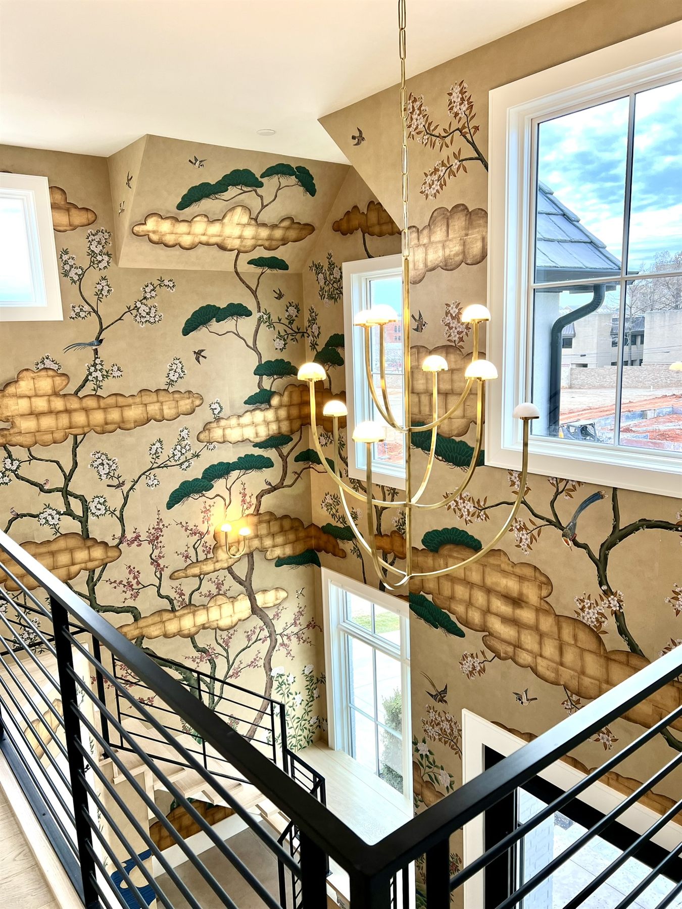 Two-story stairwell with cloud chinoiserie wallpaper